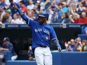 Jose Reyes of the Toronto Blue Jays salutes Melky Cabrera, who drove Reyes in with a double in the third inning during MLB game action against the Tampa Bay Rays on August 23, 2014 at Rogers Centre. (Tom Szczerbowski/Getty Images/AFP)