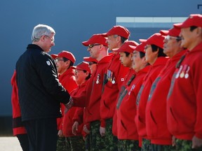 Canada's Prime Minister Stephen Harper (L) shakes hands with Canadian Rangers upon arrival in Cambridge Bay, Nunavut August 23, 2014. Harper is on the third day of his annual tour of Northern Canada. REUTERS/Chris Wattie