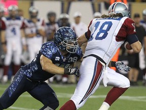 Winnipeg Blue Bombers LB Ian Wild tackles Montreal Alouettes QB Jonathan Crompton during CFL action at Investors Group Field in Winnipeg, Man., on Fri., Aug. 22, 2014.