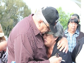 Tina Fontaine's great-aunt and uncle, Thelma and Joseph Favel, watch as Fontaine's body is taken away to be cremated after her funeral at Fort Alexander Church on Sakeeng  First Nation Aug. 23, 2014.