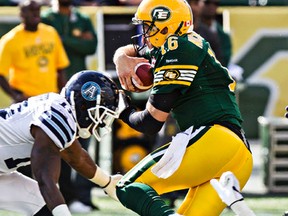 Edmonton's quarterback Matt Nichols (16) is tripped up by Toronto's Tristan Okpalaugo (91) during the Edmonton Eskimos' CFL football game against the Toronto Argonauts at Commonwealth Stadium in Edmonton, Alta., on Saturday, Aug. 23, 2014. The Eskimos won by a score of 41-27. Codie McLachlan/Edmonton Sun/QMI Agency