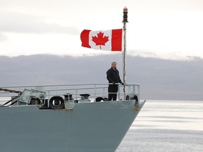 Prime Minister Stephen Harper stands on the front deck of the HMCS Kingston on Eclipse Sound, near the arctic community of Pond Inlet, Nunavut Aug. 24, 2014. Harper is on his annual tour of Northern Canada. REUTERS/Chris Wattie