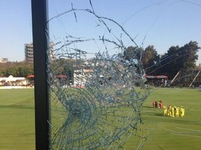 Former Zimbabwe Test bowler Mpumelelo Mbangwa Tweeted this image from his commentary booth at the Australia-Zimbabwe one-day international cricket match on Aug. 25, 2014, in Harare. "I'm OK! *Said in Rob Schneider voice* Just can't see the field too clearly now. Some hit!!" Mbangwa commented in the Tweet after a shot by Australia's Mitchell Johnson broke the glass. (TWITTER.COM/@MMBANGWA)