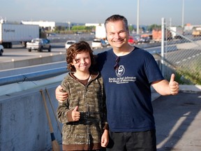 Kevin Jackal Johnston and his son Brayden, 11, hung a banner overlooking the 401 in Mississauga August 25, 2014. (Matt Ingram/Toronto Sun)