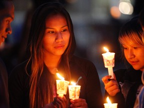 Kia Rain,14, middle, gathers with her friends at a candle light vigil at Sir Winston Churchill Square in Edmonton, AB on August 21, 2014 to remember missing and murdered Aboriginal women, most recently Tina Fontaine, 15, who was found wrapped in a bag and dumped in the Red River in Manitoba on Sunday. TREVOR ROBB/Edmonton Sun/QMI Agency
