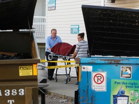 Edmonton Medical Examiner personnel remove the body of a male from a basement suite of Lorraine Manor at 10727-110 St., in Edmonton, Alta., on Monday, August 25, 2014. Tom Braid/Edmonton Sun/QMI Agency