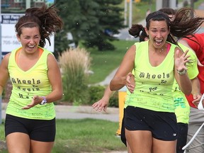 Julia and Maria McInnis of Timmins, celebrate as they make it to the finnish of their 300km run from Timmins to Sudbury on Monday August 25/2014 in support of the Canadian Cancer Society's Wheels of Hope tramportation program.
Gino Donato/The Sudbury Star