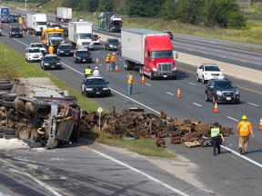 Highway traffic is slowed down as emergency crews work to clean scrap metal off Highway 401 at Veterans Memorial Parkway after a truck tipped, spilling it's load across the busy road, at the eastbound on ramp in London, Ontario on Tuesday August 26, 2014.
CRAIG GLOVER/The London Free Press/QMI Agency?