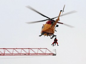 Crews in a CH-146 Griffon rescue helicopter from 8 Wing CFB Trenton rescue a crane operator during a massive construction-site fire in Kingston on Tuesday, Dec. 17, 2013. (Ian MacAlpine/The Whig-Standard)