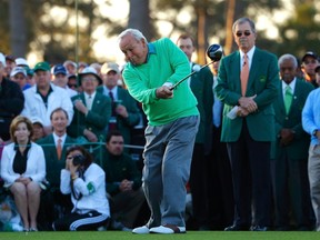 Former Masters champion Arnold Palmer hits his drive during the ceremonial start as Augusta National Golf Club Chairman Billy Payne looks on at the 2014 Masters in Augusta, Ga. on April 10, 2014. (Brian Snyder/Reuters/Files)