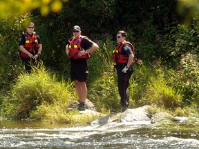 Ottawa police examine the area where a body was found in the rapids of the Rideau River at Carleton University on Tuesday before 11 a.m. (TONY CALDWELL Ottawa Sun)
