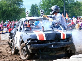 Clayton Berger of Middlemarch climbs out of his car after being knocked out in a heat at the demolition derby at the Shedden Fair. (PATRICK BRENNAN, For the Times-Journal)