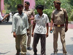 Indian policemen show two men (L and 2nd R), who are accused of gang raping and hanging two girls, to the media at Budaun district in the northern Indian state of Uttar Pradesh May 30, 2014. REUTERS/Stringer