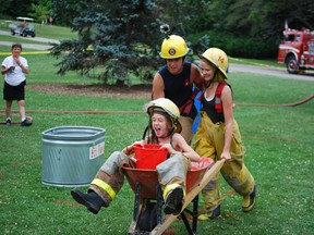 Firefighter competitions are a major part of the 32nd annual St. Thomas Fire Muster. At last year's edition McKenzie Dowd, left, and Hailey Verstlaete of Blenheim pushed Laurin Ainsworth in a wheelbarrow during a bucket brigade game. (Ben Forrest, Times-Journal)