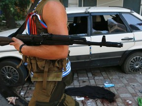 A pro-Russian separatist walks past a car which was damaged by what locals say was recent shelling by Ukrainian forces, in Donetsk, eastern Ukraine August 27, 2014. (REUTERS/Maxim Shemetov)