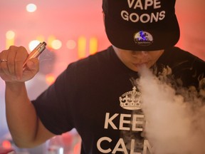 Alex Lin, 29, blows a cloud while 'vaping' or exhaling vapour from a BCV XXIX mod, or personal vapourizer, with a Patriot atomizer after attending a vapour cloud competition at the The Henley Vaporium in Lower Manhattan, New York July 26, 2014. (REUTERS/Elizabeth Shafiroff)