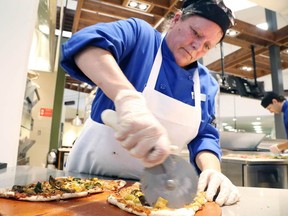 Gino Donato/The Sudbury Star
Food services worker Deedee Aubrey cuts pizza in the newly renovated Great Hall at Laurentian University on Wednesday.