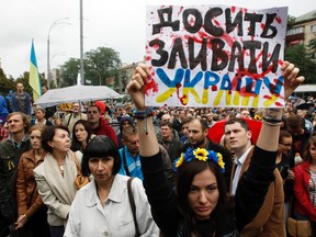 Public activists and relatives of soldiers who say that the soldiers are surrounded by pro-Russian separatists in eastern Ukraine, take part in a protest in front of the defence ministry building in Kiev, August 28, 2014. The poster reads: "Stop pissing away Ukraine" REUTERS/Valentyn Ogirenko