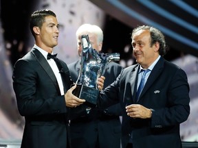 Real Madrid's Cristiano Ronaldo (L) receives his Best Player UEFA 2014 Award from UEFA President Michel Platini during the draw ceremony for the 2014/2015 Champions League Cup soccer competition at Monaco's Grimaldi Forum in Monte Carlo August 28, 2014.  (REUTERS)