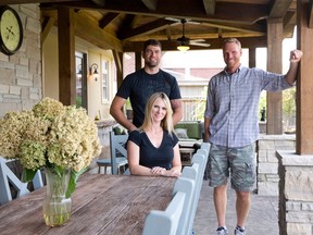 Josh McBurney of Valley View Timberworks, right, poses with homeowners Jen LeClair and Bob Vanhouwelingen under the rustic outdoor addition he built at their home in Ilderton. (CRAIG GLOVER, The London Free Press)