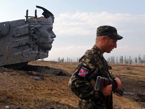A Pro-Russian separatist stands near the damaged war memorial at Savur-Mohyla, a hill east of the city of Donetsk, August 28, 2014. REUTERS/Maxim Shemetov
