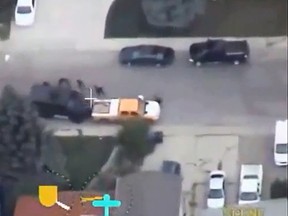 Saskatoon police are shown rescuing people who took cover behind a parked car during an armed standoff.
(Screenshot from YouTube)