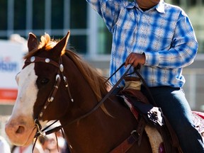 Calgary mayor Naheed Nenshi waves to the crowd while riding a horse during the 102nd Calgary Stampede parade in Calgary, Alberta, July 4, 2014. REUTERS/Todd Korol  (CANADA - Tags: SOCIETY POLITICS ANIMALS)
