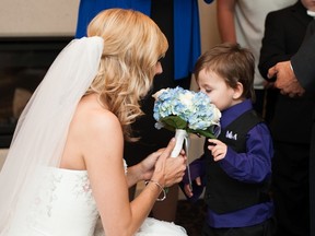 Megan Wolfe Melnyk shares a moment with one of her and new husband, Josh Melnyk’s, youngest sons. The flower arrangements were generously donated by Spruce Grove Flowers. - Photo by Blake Loates Photography