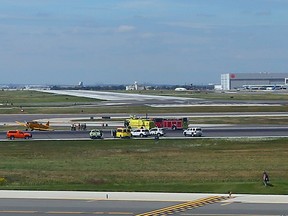 Emergency crews at Pearson International Airport work to clear a Canadian Harvard that skidded off the runway at Pearson International Airport Toronto on Aug. 29, 2014. (Dave Abel/Toronto Sun)