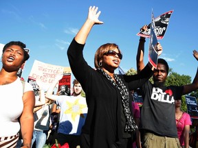 Protesters march with their hands up as they call for a thorough investigation of the shooting death of teen Michael Brown in Ferguson, Missouri. (REUTERS/Larry Downing)