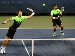 Daniel Nestor of Canada returns a shot to Colin Fleming of Great Britain and Ross Hutchins of Great Britain while playing with his partner Nenad Zimonjic of Serbia during their men's doubles first round match on Day Two of the 2014 US Open at the USTA Billie Jean King National Tennis Center on August 26, 2014 in the Flushing neighborhood of the Queens borough of New York City.  (Matthew Stockman/Getty Images/AFP)