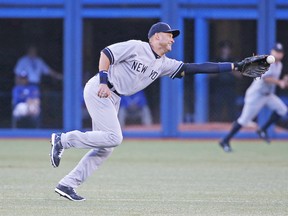 Derek Jeter, starting his final series in Toronto before retiring at the end of this season, has the ball go off the end of his glove on this single up the middle by Blue Jays’ Dioner Navarro on Friday night at the Rogers Centre. (Tom Szczerbowski, AFP)