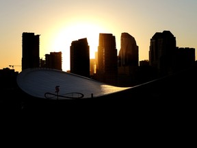 Downtown Calgary skyline at sunset framed by the Scotiabank Saddledome