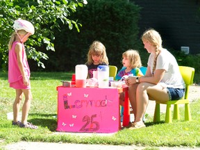 Young Anna McClenaghan gives her sales pitch to Evelyn Helland, 6, at a lemonade stand in London Friday with older sister Ruby and sitter Emma Hamber. Such childish delights in summer?s dying days are in sharp contrast to the 25,000 area kids who will arrive at school hungry next week. (DEREK RUTTAN, The London Free Press)