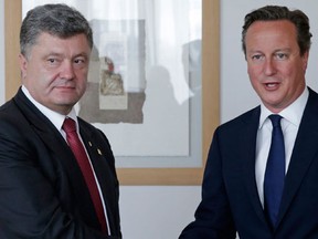 Ukrainian President Petro Poroshenko (L) meets with Britain's Prime Minister David Cameron ahead of an European Union summit in Brussels August 30, 2014. At a summit in Brussels that may hand one of the Union's top jobs to Poland's premier and give hawkish Kremlin critics in ex-communist Eastern Europe new influence in the bloc, EU officials gave Ukraine's embattled President Poroshenko a warm welcome and assurances of further economic and other support. (REUTERS/Yves Logghe/Pool)