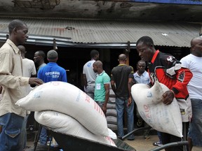 Residents of West Point neighbourhood, which has been quarantined following an outbreak of Ebola, receive food rations from the United Nations World Food Program (WFP) in Monrovia on August 28, 2014. (REUTERS/2Tango)