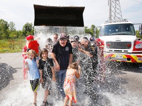 Tyendinaga, Ont. firefighters give their Belleville, Ont. counterparts at Stations 3 and 4 a freezing taste of their own medicine by challenging a dozen city firefighters, their family members and friends to take the ALS Ice Bucket Challenge at Station 4 on Harmony Road  Saturday afternoon, Aug. 30, 2014. — JEROME LESSARD/THE INTELLIGENCER/QMI AGENCY