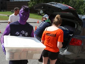 Bio-med student Adam Chenier sorts out stickers for his luggage and belongings as student volunteers prepare to carry his stuff into his new residence unit at Carleton Saturday, Aug. 30, 2014.
DOUG HEMPSTEAD/Ottawa Sun/QMI AGENCY