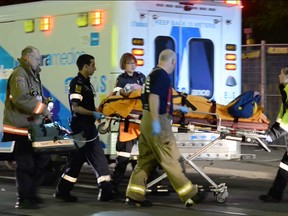A 16-year-old is cared for by emergency services after suffering serious injuries on St. Clair Ave. W. near Bathurst St. aroudn 1 a.m. on Aug. 30, 2014. (Andrew Collins/Special to the Toronto Sun)
