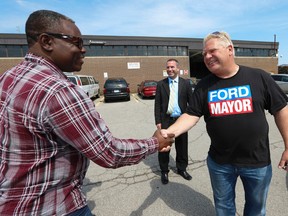 Doug Ford shakes hands with Joseph outside of the Ford Nation HQ in Etobicoke on Belfield Rd. on Aug. 30, 2014. (Jack Boland/Toronto Sun)