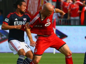 Michael Bradley of Toronto FC battles for the ball against Daigo Kobayashi of New England Revolution during MLS action on Aug. 30. (Dave Abel, Toronto Sun)