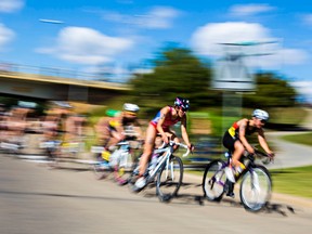 A pack of triathletes makes its way down River Valley Road during the 2014 ITU World Triathlon Grand Final Edmonton elite women's race at Hawrelak Park in Edmonton, Alta., on Saturday, Aug. 30, 2014. Codie McLachlan/Edmonton Sun/QMI Agency