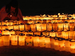 A girl lights candles during a candlelight memorial held in remembrance of victims of the March 11, 2011 earthquake and tsunami in Iwaki, Fukushima prefecture in this March 9, 2014 file photo.  REUTERS/Toru Hanai