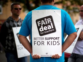 Teachers from Brittania School wear signs while on strike in Vancouver, British Columbia June 17, 2014. British Columbia teachers across the province are on strike due to failed negotiations with the provincial government. (Reuters/Ben Nelms)