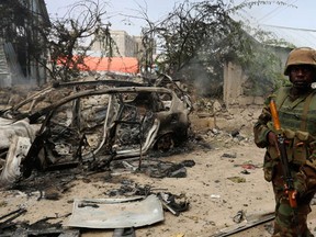 Ugandan soldiers serving in the African Union Mission in Somalia (AMISOM) patrol in a formation near the Jilacow underground cell inside a national security compound after an attack by suspected militants in Mogadishu August 31, 2014. Islamist rebels blew up a car bomb and gunmen attacked the national-intelligence site in Somalia's capital where suspected militants are held, in an assault on Sunday that left 11 people dead, government officials and the rebel group said. (Reuters/Feisal Omar)