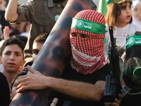 A Palestinian Hamas supporter holds a model of a rocket during a rally celebrating what organizers say was a victory by Palestinians in Gaza over Israel following a ceasefire, in the West Bank city of Nablus August 29, 2014. (REUTERS/Abed Omar Qusini)