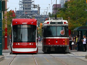 The new streetcar makes its way down Spadina past an older model on Sunday, August 31, 2014. (Dave Abel/Toronto Sun)