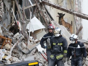 Firefighters search the rubble of a collapsed building in Rosny-Sous-Bois, near Paris on August 31, 2014. (REUTERS/Christian Hartmann)