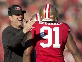 Head coach Jim Harbaugh congratulates defensive tackle Ray McDonald #91 of the San Francisco 49ers on his sack of quarterback Russell Wilson #3 of the Seattle Seahawks in the second quarter on December 8, 2013 at Candlestick Park in San Francisco, California. The 49ers won 19-17.   (Brian Bahr/Getty Images/AFP)