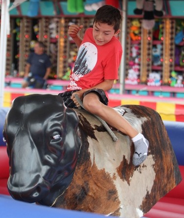 Sunday, Aug. 31, 2014 Ottawa -- Adam Tremblay, 10, of Gatineau tries to hang on to the mechanical bull during the annual Gatineau Hot Air Balloon festival on Sunday, Aug. 31, 2014. The festival continues Monday.
DOUG HEMPSTEAD/Ottawa Sun/QMI AGENCY